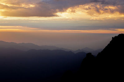 Scenic view of silhouette mountains against sky at sunset