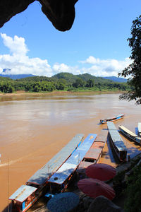 Boats moored on shore against sky