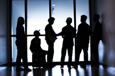 Silhouette band 5 people standing by airplane window