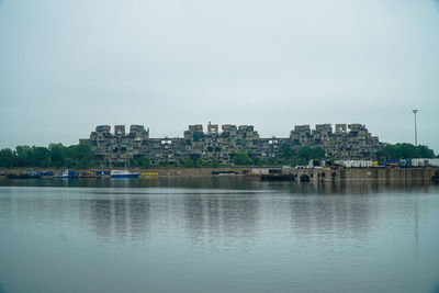 River by cityscape against clear sky