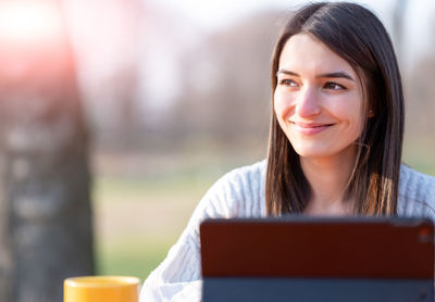 Portrait of young woman using digital tablet