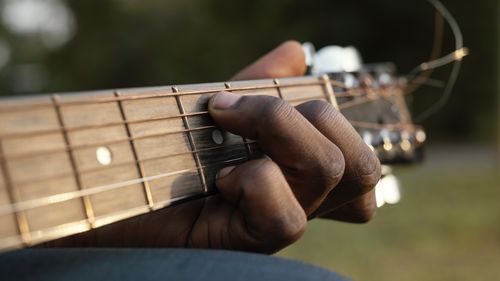 Cropped hand of man playing guitar