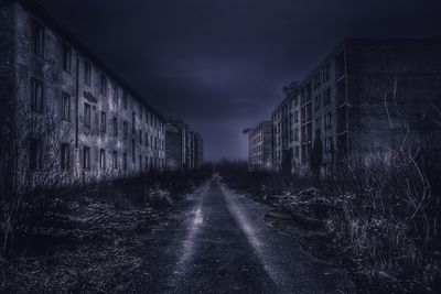 Road amidst buildings in city against sky