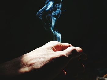 Close-up of human hand against black background