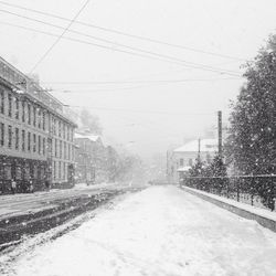 Snow covered road in city