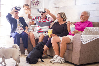 Senior couple using virtual reality with family and dogs at home