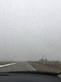 Close-up of wet road against sky during rainy season