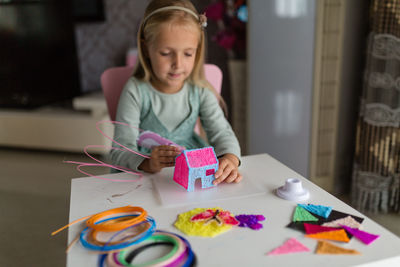 Portrait of cute girl painting on table