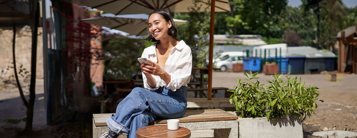 Portrait of smiling young woman using mobile phone