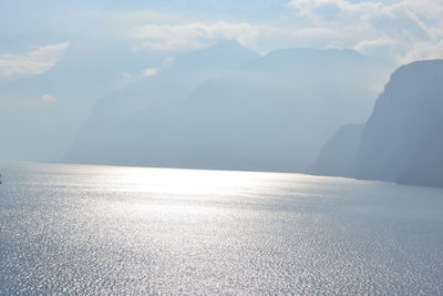 Scenic view of lake by mountains against sky