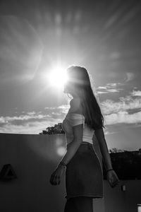 Woman looking at camera against sky