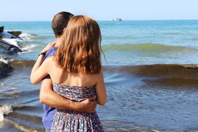 Rear view of woman standing on beach