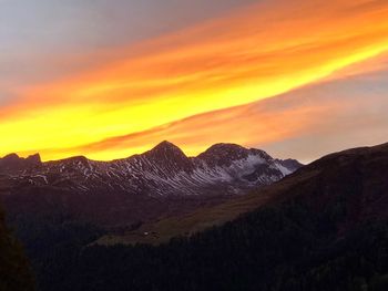 Scenic view of mountains against orange sky