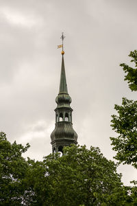 Low angle view of clock tower amidst trees and building against sky