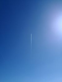 Low angle view of vapor trail against blue sky