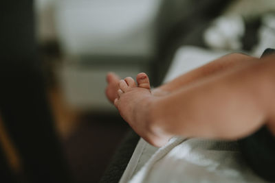 Low section of baby boy on bed at home