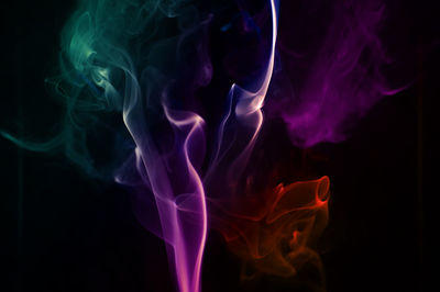 Close-up of colorful abstract smoke pattern against black background