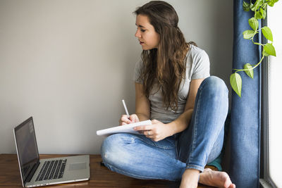 Individual woman on her laptop working / studying at home