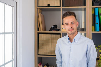 Portrait of young man standing at home