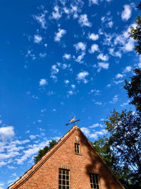 Low angle view of building and trees against sky