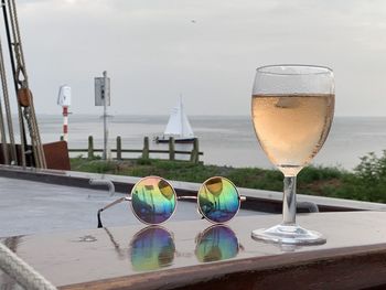 Close-up of beer in swimming pool against sea