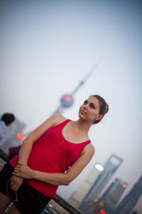 Thoughtful woman standing against clear sky