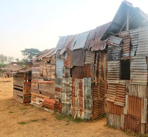 Old wooden house on field against clear sky