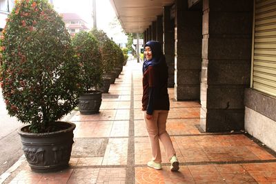 Portrait of woman standing on sidewalk