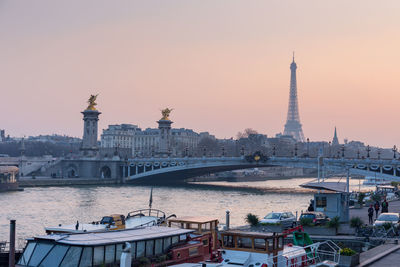 Pont alexandre iii over seine river with eiffel tower against sky