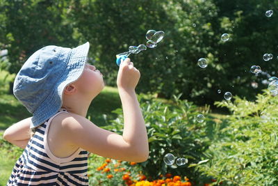 Girl blowing bubbles in park