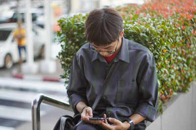 Man talking using mobile phone while sitting outdoors