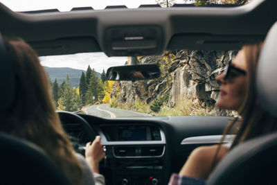 Rear view of female friends traveling in car