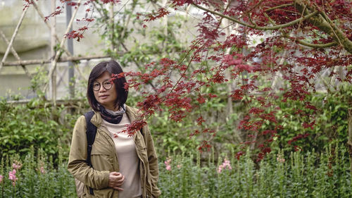 Portrait of woman standing against trees