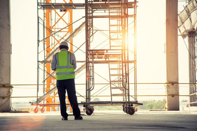 Rear view of man walking at construction site