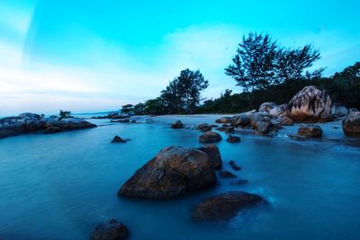 Scenic view of rocks in sea against sky