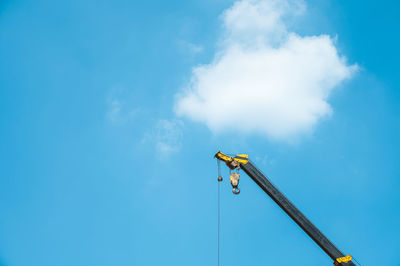 Low angle view of crane against blue sky