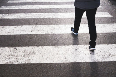 Low section of woman walking on road