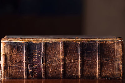 Close-up of old books on table against black background