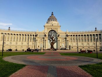 Government building by field against sky