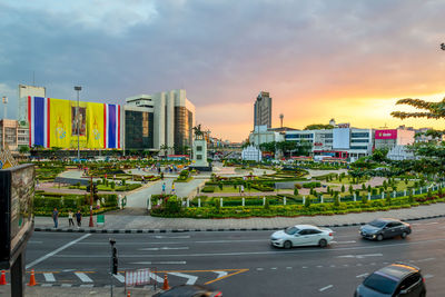 City street and buildings against sky during sunset