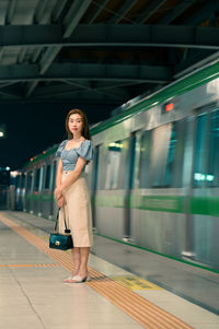 Full length of young woman standing in subway