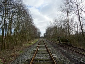 Railroad track against cloudy sky