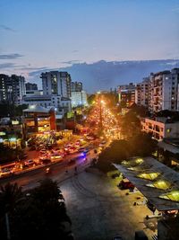 High angle view of illuminated street amidst buildings at night