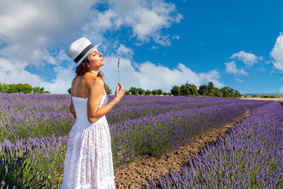 Woman with closed eyes sniffing lavender flowers. concept of summer and wellness in nature. 