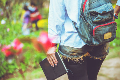 Midsection of man holding umbrella standing on field