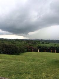 Scenic view of grassy field against cloudy sky