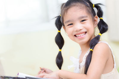 Close-up portrait of smiling girl sitting outdoors