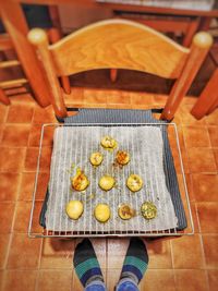 Low section of person standing on tiled floor by food