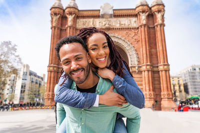 Portrait of smiling young woman standing in city