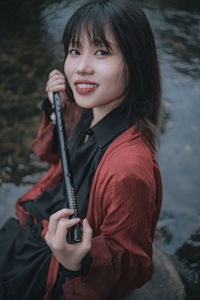 Portrait of young woman holding electronic cigarette